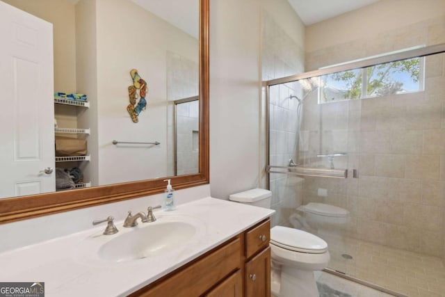 bathroom with toilet, vanity, and an enclosed shower