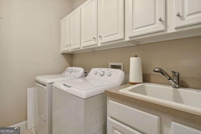 washroom with washing machine and dryer, sink, and cabinets