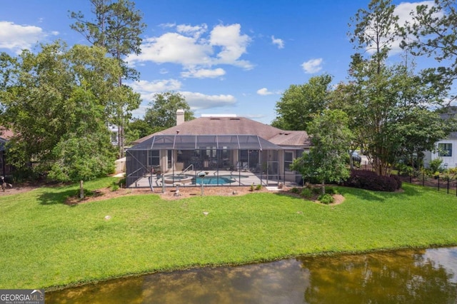 back of property with a water view, a lawn, and glass enclosure