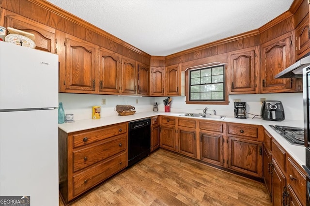 kitchen with stainless steel gas stovetop, light hardwood / wood-style floors, black dishwasher, white refrigerator, and sink