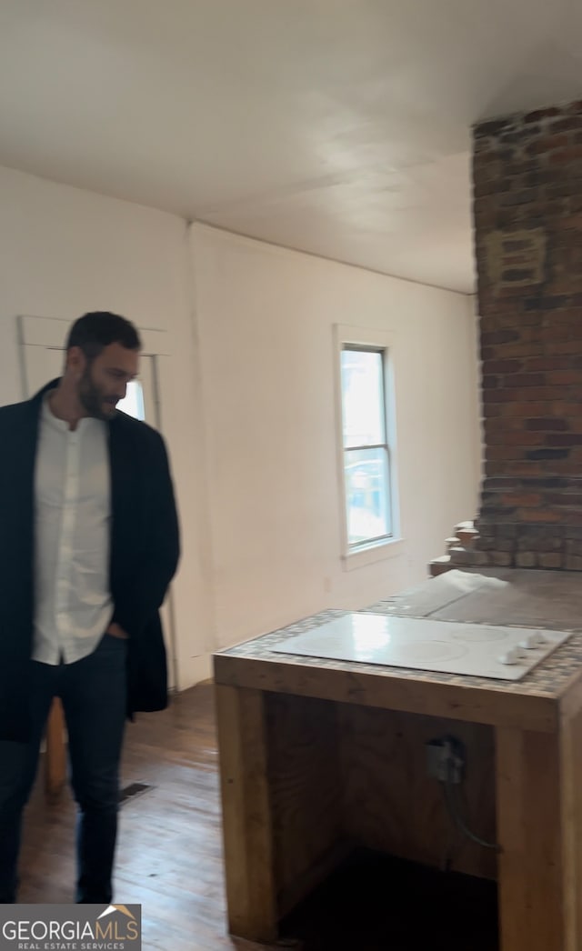 office with wood-type flooring and brick wall