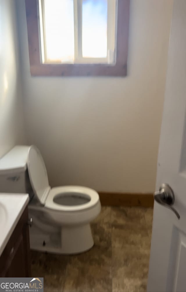 bathroom featuring vanity, tile patterned flooring, and toilet