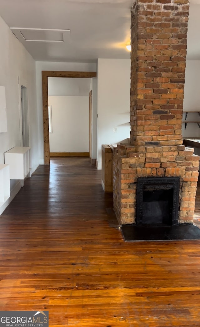 hall featuring hardwood / wood-style floors and brick wall