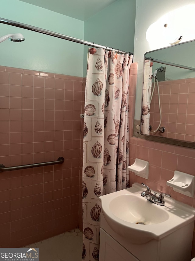 bathroom with decorative backsplash, vanity, curtained shower, and tile walls