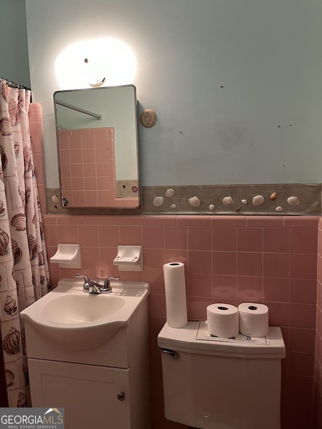 bathroom with vanity and tile walls