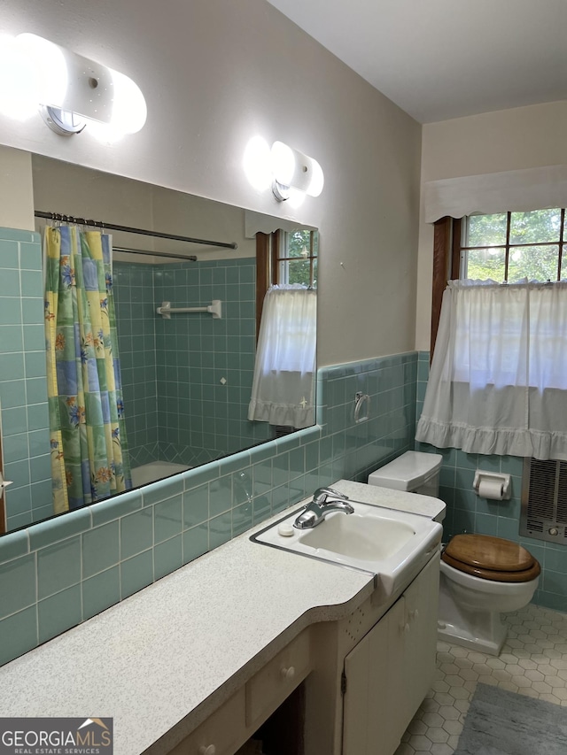 full bathroom with tile walls, vanity, tile patterned floors, toilet, and shower / bath combo with shower curtain