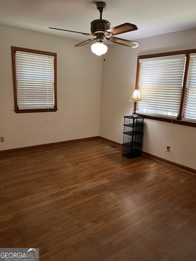 unfurnished room with ceiling fan and dark hardwood / wood-style flooring