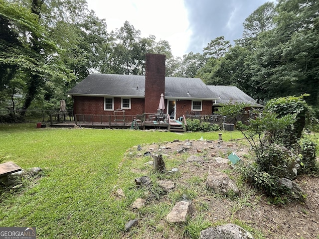 back of property with a deck and a lawn