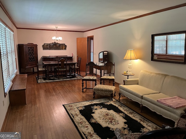 living room with hardwood / wood-style flooring, crown molding, a wealth of natural light, and an inviting chandelier