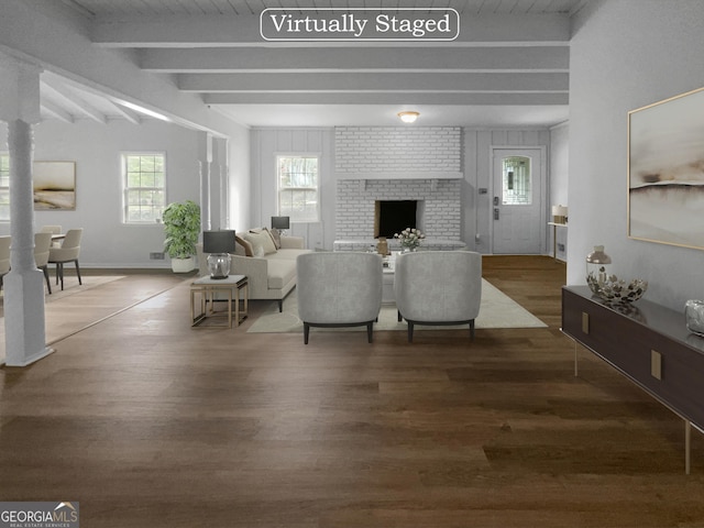 living room with dark hardwood / wood-style floors, beam ceiling, and a brick fireplace