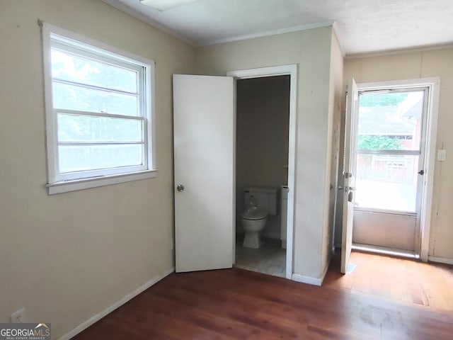 unfurnished bedroom with hardwood / wood-style flooring and connected bathroom