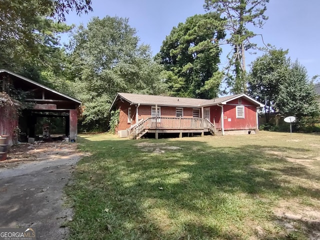 rear view of property with brick siding, a yard, and a deck