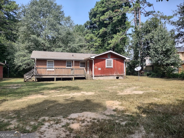 view of front of property featuring a deck and a front lawn