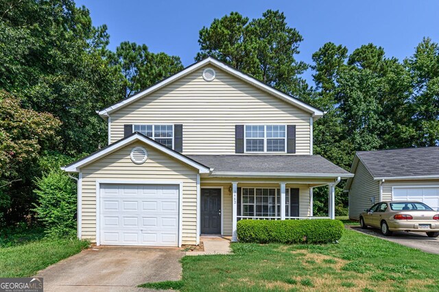 view of front property featuring a garage, a porch, and a front lawn