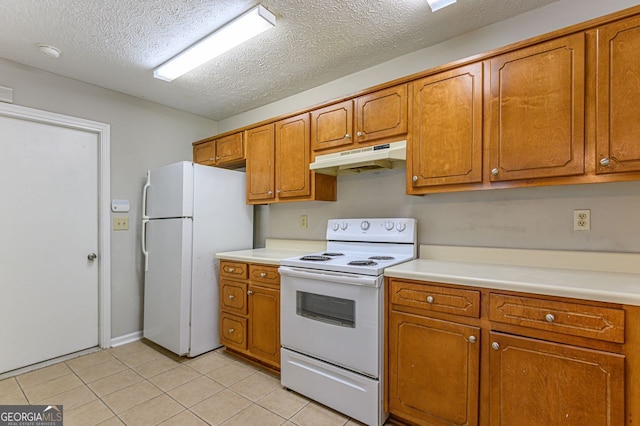 kitchen with light tile patterned floors, white appliances, and a textured ceiling