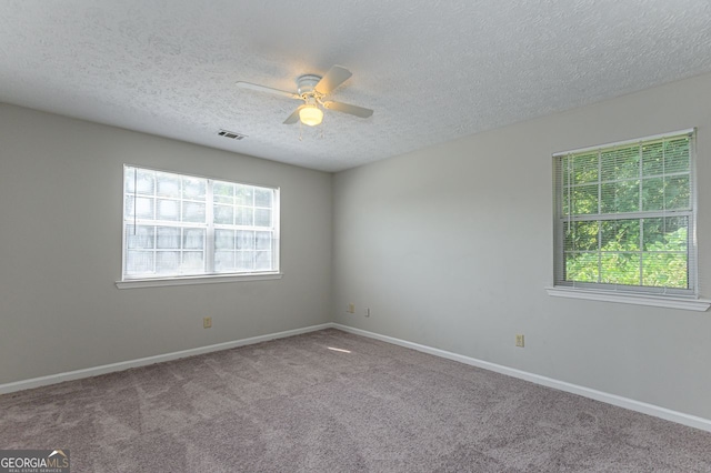 carpeted spare room featuring ceiling fan and a textured ceiling