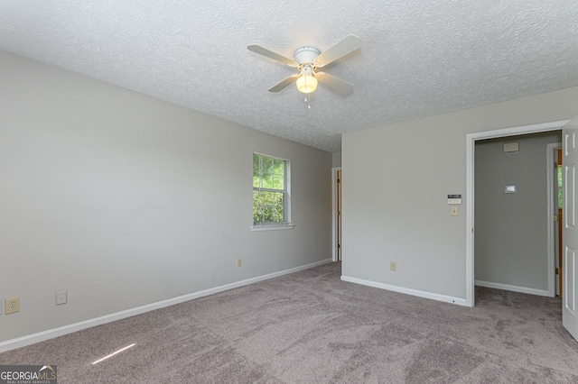 spare room with ceiling fan, light colored carpet, and a textured ceiling