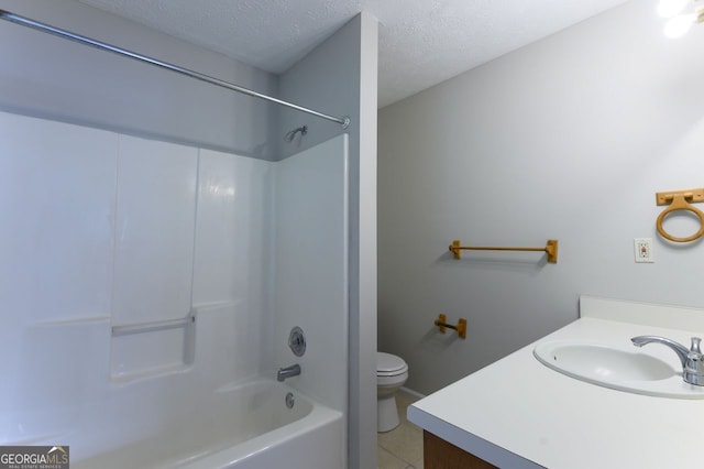 full bathroom with washtub / shower combination, tile patterned floors, toilet, a textured ceiling, and vanity