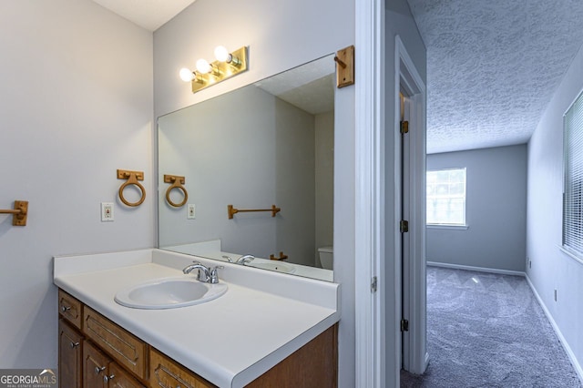 bathroom with vanity, a textured ceiling, and toilet