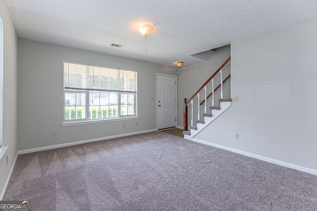 entrance foyer featuring carpet and a textured ceiling