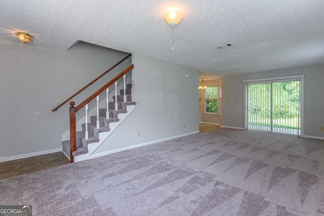 unfurnished living room featuring carpet and a textured ceiling