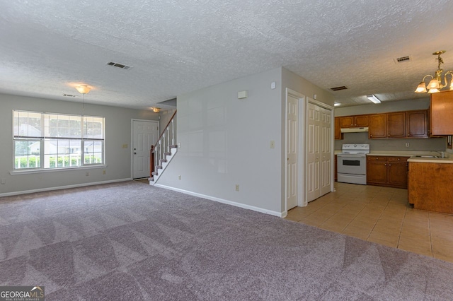 kitchen with white electric range, sink, an inviting chandelier, pendant lighting, and light colored carpet