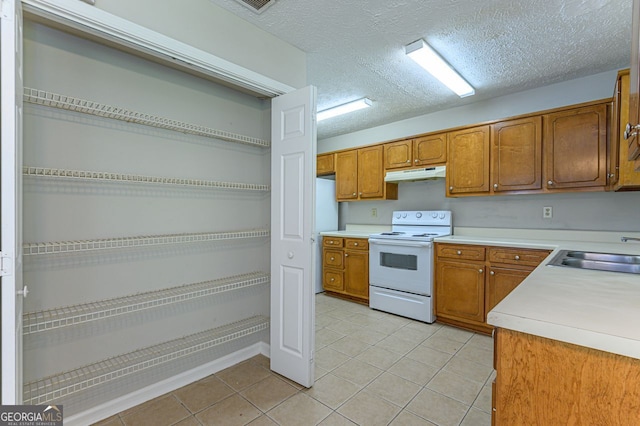 kitchen with sink, white electric stove, a textured ceiling, and light tile patterned flooring