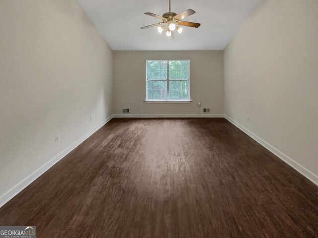 unfurnished room featuring dark wood-type flooring and ceiling fan