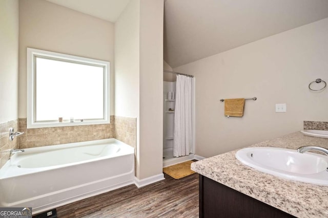 bathroom with vanity, hardwood / wood-style flooring, plus walk in shower, and vaulted ceiling