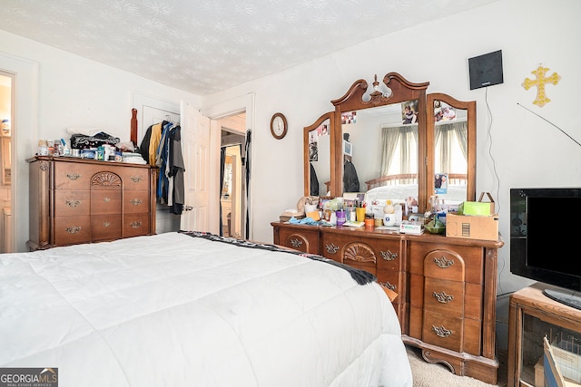 carpeted bedroom featuring a textured ceiling and a closet