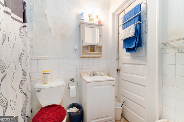 bathroom with vanity, tasteful backsplash, curtained shower, tile walls, and toilet