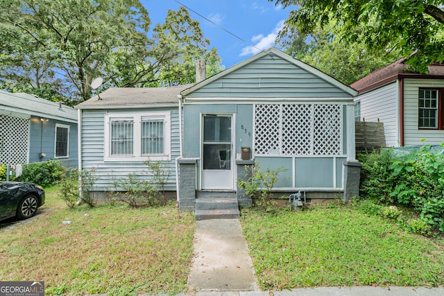 bungalow-style house featuring a front lawn