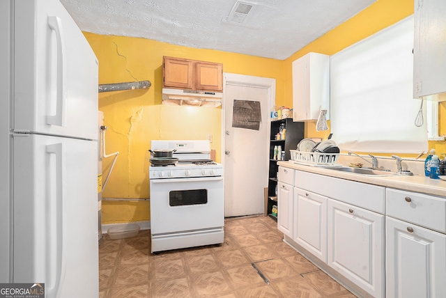 kitchen with sink, a textured ceiling, white cabinets, light parquet floors, and white appliances