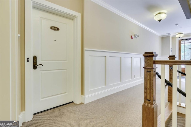 corridor with ornamental molding and light carpet