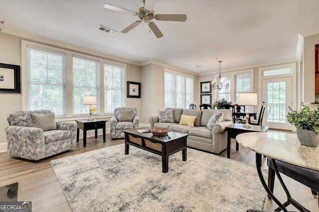 living room featuring ceiling fan with notable chandelier, ornamental molding, and light hardwood / wood-style floors