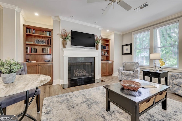 living room with ceiling fan, light hardwood / wood-style flooring, and crown molding