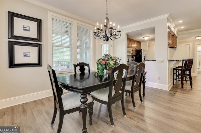 dining room featuring crown molding, light wood-type flooring, and a chandelier