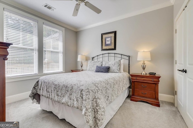 bedroom with ceiling fan, light colored carpet, a closet, and ornamental molding