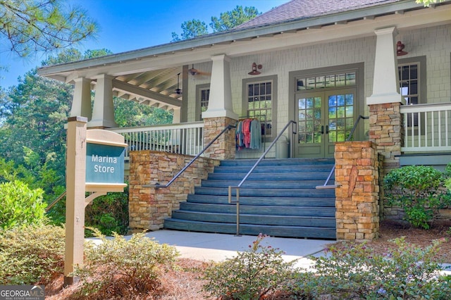 view of exterior entry with french doors and a porch