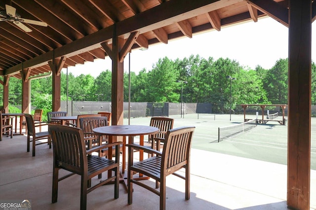 view of patio / terrace with ceiling fan and tennis court