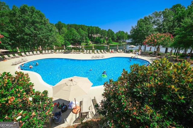 view of pool featuring a patio area and a water view