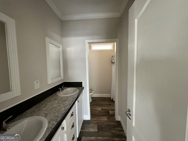 bathroom featuring vanity, toilet, wood-type flooring, and ornamental molding