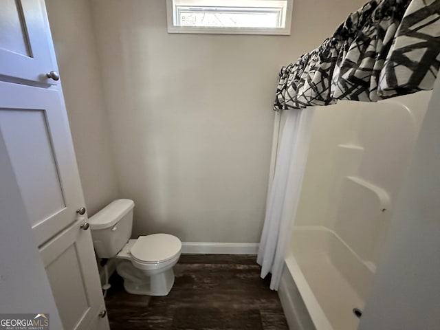 bathroom featuring wood-type flooring, toilet, and shower / bathtub combination with curtain