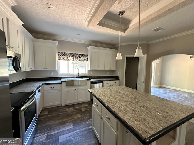 kitchen with white cabinetry, hanging light fixtures, stainless steel appliances, and dark wood-type flooring