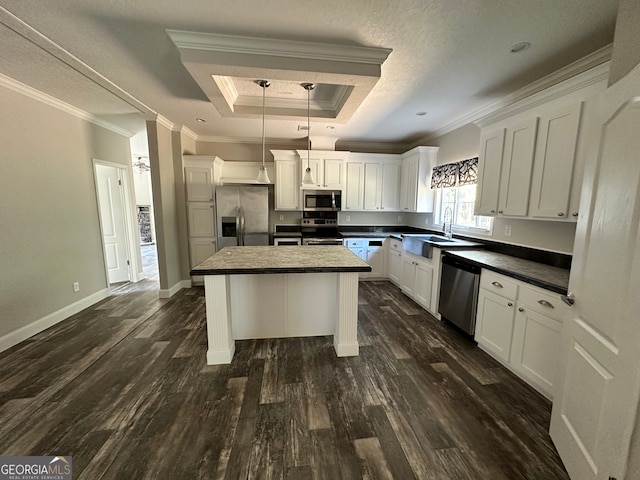 kitchen with dark hardwood / wood-style flooring, appliances with stainless steel finishes, a center island, crown molding, and decorative light fixtures