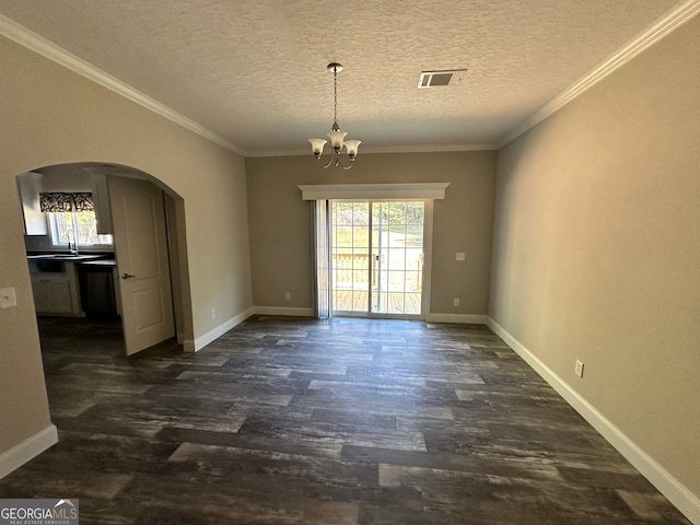 spare room featuring an inviting chandelier, dark wood-type flooring, crown molding, and a textured ceiling