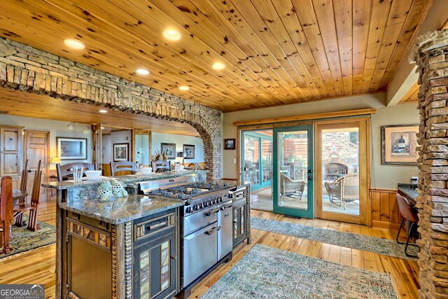 kitchen with light wood-type flooring, stainless steel appliances, wooden ceiling, dark brown cabinetry, and sink