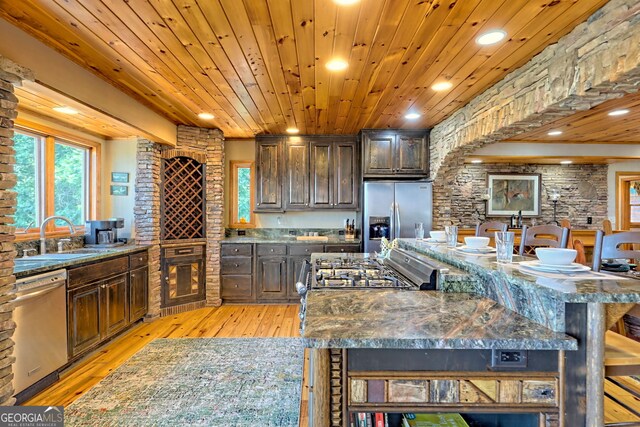 kitchen featuring stainless steel appliances, dark stone countertops, dark brown cabinetry, light hardwood / wood-style floors, and wood ceiling