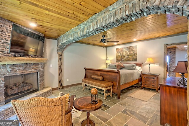 bedroom with tile patterned flooring, a fireplace, ceiling fan, and wooden ceiling