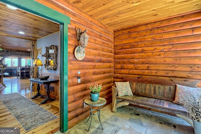 sitting room with log walls and wooden ceiling